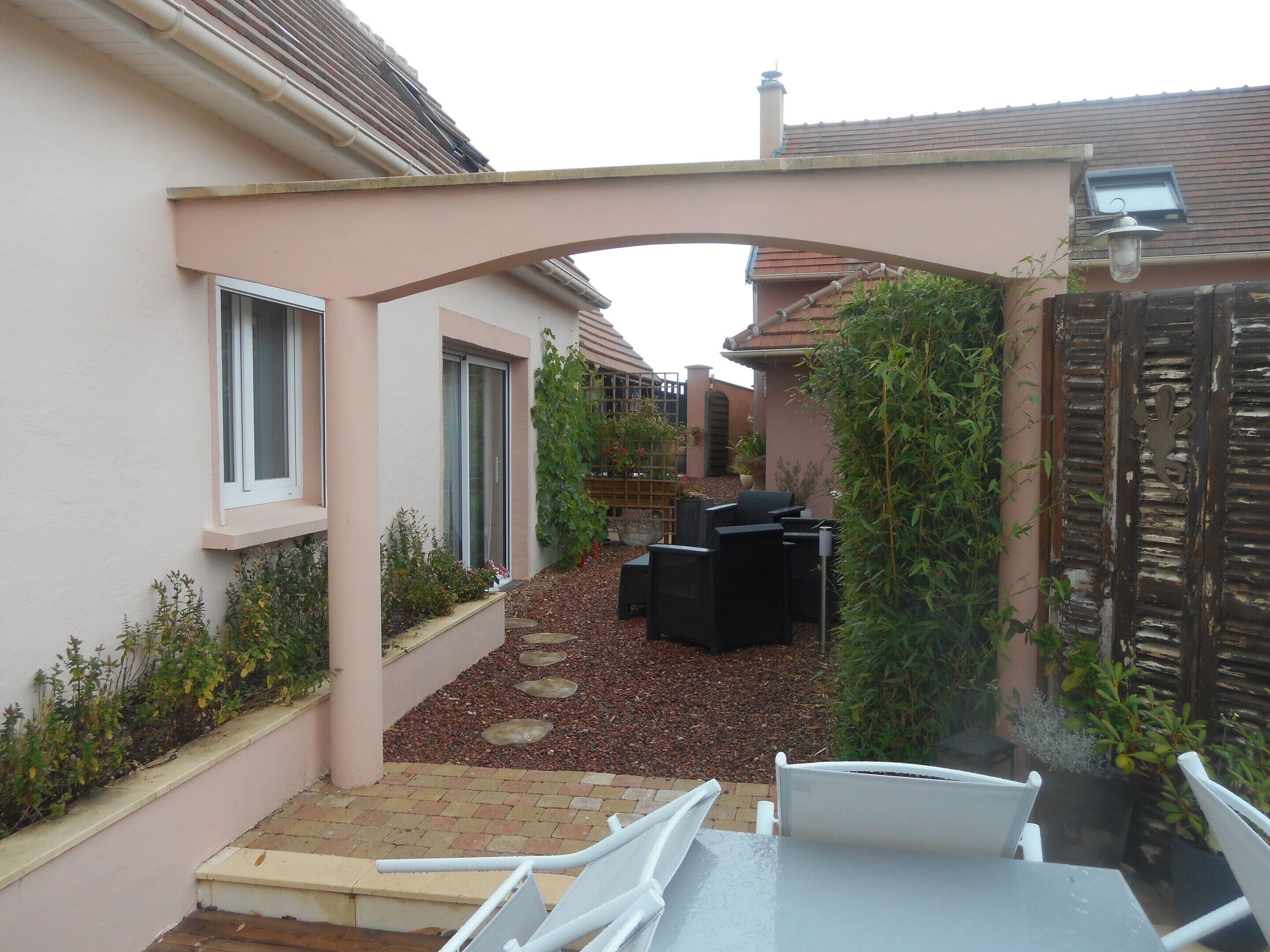 A patio area with outdoor furniture, a covered seating area, and a view of the adjacent building.