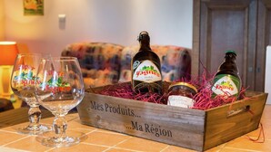 Une boîte en bois contenant des bouteilles et des verres, le tout posé sur une table carrelée, et portant l'étiquette « Vagnes Scotch ».