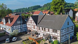 A traditional half-timbered building with a courtyard, surrounded by other similar structures.