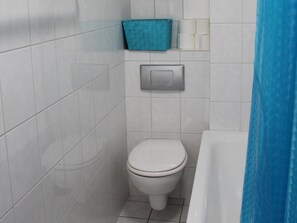 A small bathroom with a toilet, a blue basket, and a paper towel dispenser. - Classic Holiday Home in Harz near Braunlage Ski Area (Ilsenburg)