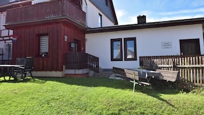 A two-story building with a red exterior and a white facade. There is a basketball hoop on the left side, and a wooden fence in front of the building. - Classic Holiday Home in Harz near Braunlage Ski Area (Ilsenburg)