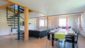 A spacious room with a dining area, a staircase, and a seating area. - Rustic Retreat, Ovifat (Waimes)