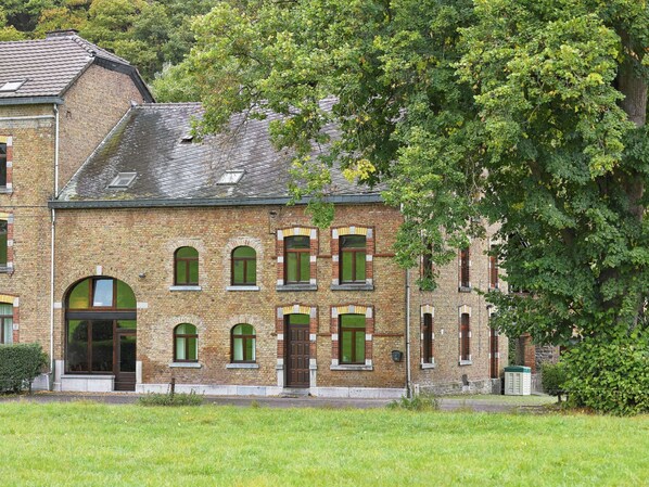 Un bâtiment en briques doté de nombreuses fenêtres et d’une entrée centrale.