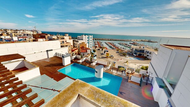 A rooftop pool with a view of the marina and sea. - APTO NAUTICO (Ampolla)