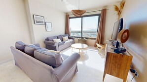 A modern living room with a sofa, a coffee table, and a TV stand. - APTO NAUTICO (Ampolla)