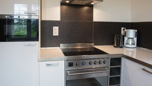 A modern kitchen with a built-in oven, a stovetop, and a coffee maker. - Mansion in Spa Liege With Private Garden (Spa)