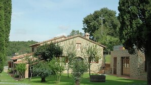 A stone building with a tiled roof, surrounded by well-maintained grass and trees. - Farmhouse Umbria-tuscany With Pool (Citta della Pieve)