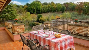 An outdoor patio with a table set for dining, surrounded by brick pillars and metal chairs. - Farmhouse Umbria-tuscany With Pool (Citta della Pieve)