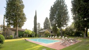 A rectangular swimming pool with a tiled deck, surrounded by a grassy lawn and stone stepping stones. - Apartment With Swimming Pool in San Casciano (San Casciano in Val di Pesa)