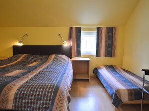 A bedroom with two beds, a desk, and a window with curtains. - Holiday Home in Robertville Near Lake & Sauna (Waimes)