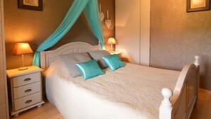 A bedroom with a canopy bed, bedside lamps, a nightstand, and a dresser. - Romantic Cottage in Ardennes (Stoumont)