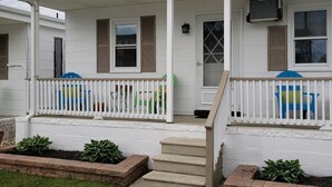 Une maison à deux étages dotée d’un porche abrité, d’une porte d’entrée et d’un escalier menant à l’entrée.