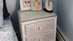 Une chambre à coucher avec un lit, une table de chevet avec une lampe et des objets décoratifs.