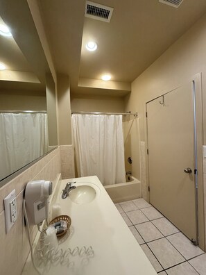 Een badkamer met wastafel, spiegel, douche en toilet.