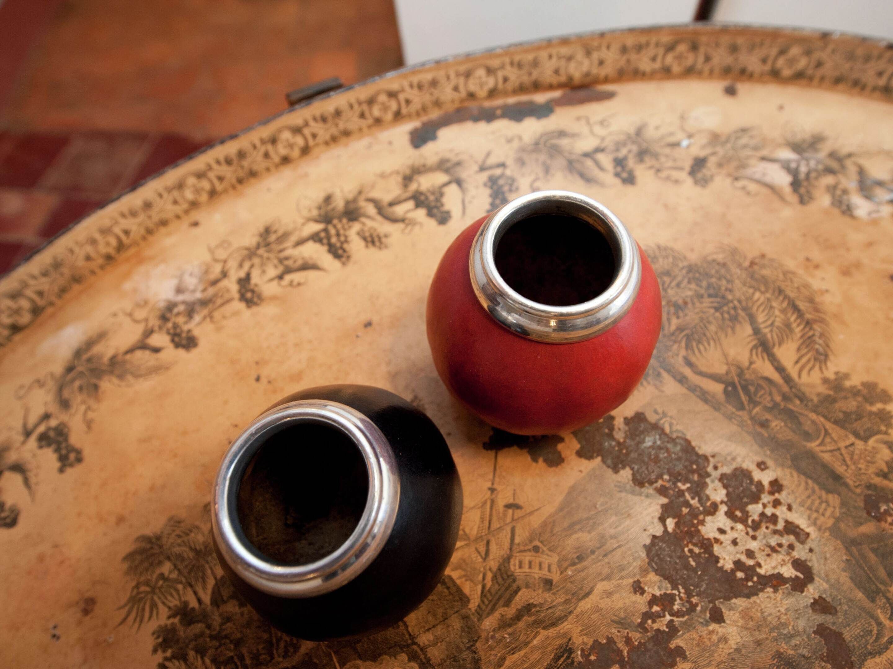 Dos jarrones sobre una mesa con un diseño detallado de paisaje.