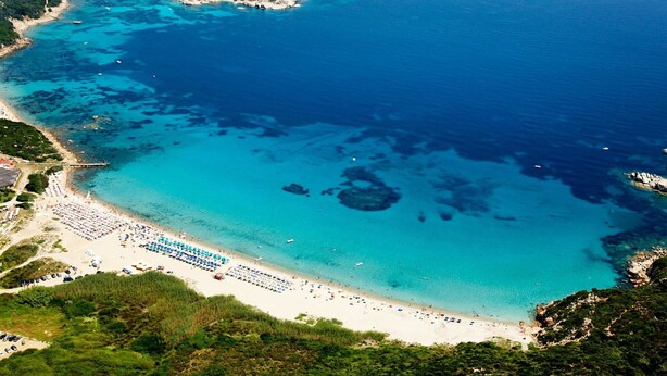 An aerial view of a coastal area with a beach, clear blue waters, and rocky outcrops. - Belvilla by OYO Comfortable Apartment With Pool (Cerignola)