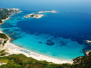 An aerial view of a coastal area with a beach, clear blue waters, and rocky outcrops. - Belvilla by OYO Comfortable Apartment With Pool (Cerignola)