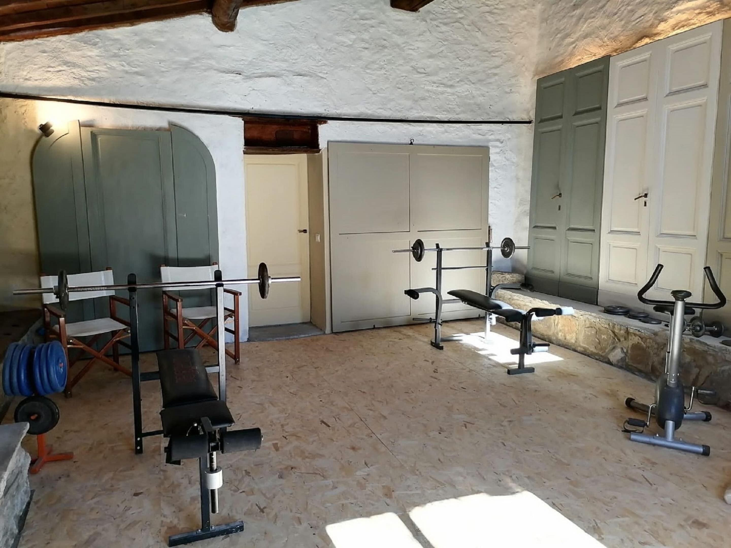 A gym with exercise equipment, a bench, and a weight bench.