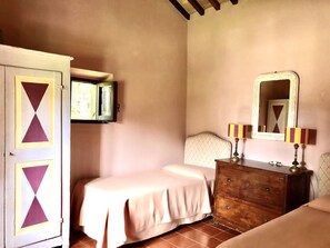 Une chambre à coucher comprenant un lit, une commode, un miroir et une armoire.