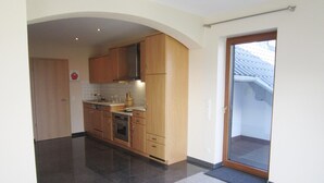 A modern kitchen with wooden cabinets, a stainless steel range hood, and a tiled backsplash.