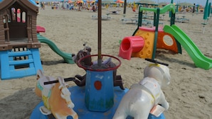 A beach playground with a horse-shaped ride, a slide, and a climbing structure. - Belvilla by OYO Lido Estensi Trilo Doria (Comacchio)
