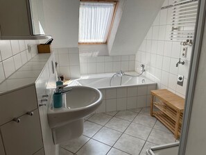 Enjoy a relaxing soak in the bathtub with handheld showerhead and sink.