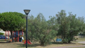 A park with a playground, a lamp post, and a path. - Belvilla by OYO Porto Garibaldi Bilo Doria (Comacchio)