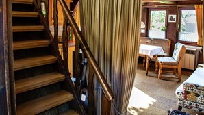 A wooden staircase leading to a dining area with a table and chairs. - Heritage Holiday Home in Wienhausen near River (Wienhausen)