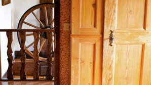 A wooden door with a brass handle, a wooden railing, and a large wooden wheel structure. - Heritage Holiday Home in Wienhausen near River (Wienhausen)