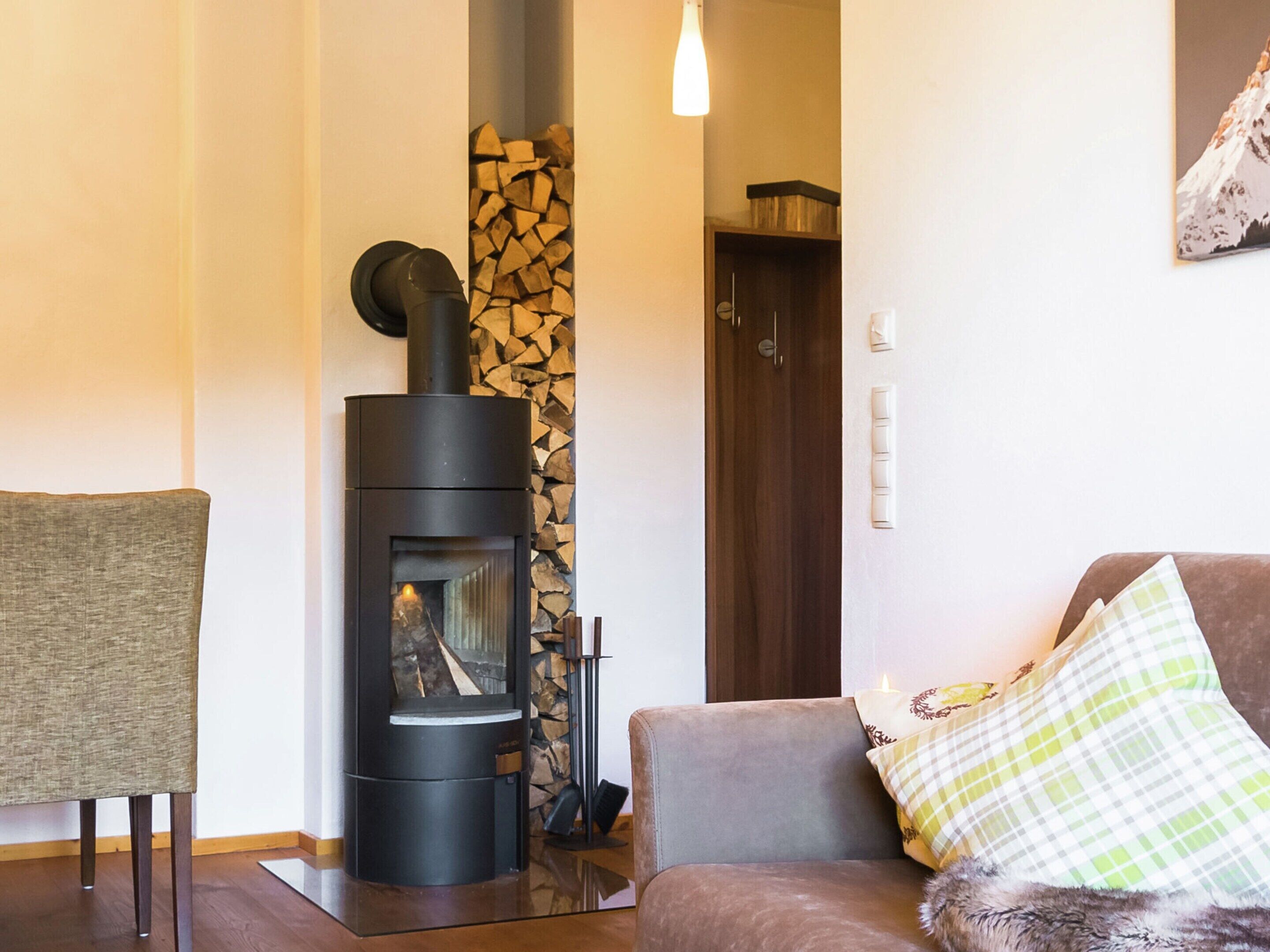 A cozy living room with a modern fireplace, a comfortable sofa, and a chair.