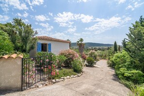 A rural house with a paved pathway, surrounded by greenery and a clear sky. - Modern Villa With Heated Pool (Beaufort)