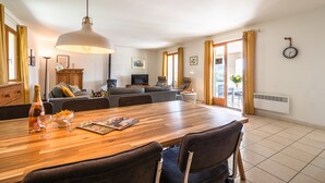 En matplats med ett träbord, stolar, en vinflaska och glas.