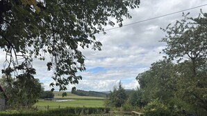 A rural landscape with a hedge, a field, and a distant view of a hill. - Ferienwohnung mit Garten auf dem Bauernhof (Trendelburg)