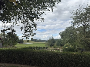A rural landscape with a hedge, a field, and a distant view of a hill. - Ferienwohnung mit Garten auf dem Bauernhof (Trendelburg)