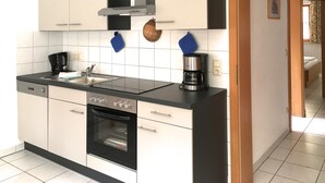 A modern kitchen with a built-in oven, a coffee maker, and a sink.