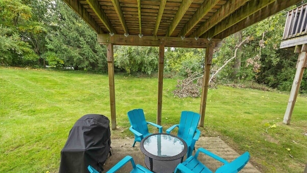 Un espace extérieur abrité, aménagé avec une table ronde et quatre chaises.
