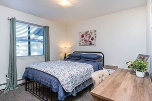 A bedroom with a bed, bedside table, lamp, and a painting on the wall. - Charming 2-unit retreat in Rockford (Rockford)