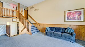 A lobby with a staircase, a blue carpet, a blue sofa, and a framed picture on the wall. - Capital O Amerihost Inn and Suites Kingdom City Hwy 54 MO (Kingdom City)