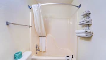 A bathroom with a shower, toilet, and towel rack.