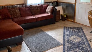 En hyggelig stue med en modulsofa, elkedel og et blåt tæppe.
