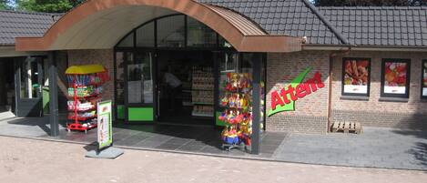 A building with a brick facade, a large entrance, and a sign that reads 'Atten'.