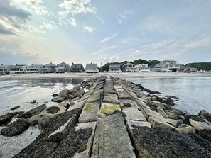 A stone pier leading to a beach with houses in the background. - Insta-worthy Couples Retreat: Perfect for romantic getaway! (Old Lyme)