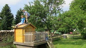 A wooden playhouse with a small deck and a white picket fence. - Gruppenfreundliche Villa in Liesen (Hallenberg)