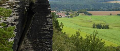 A natural rock formation with a village in the background.