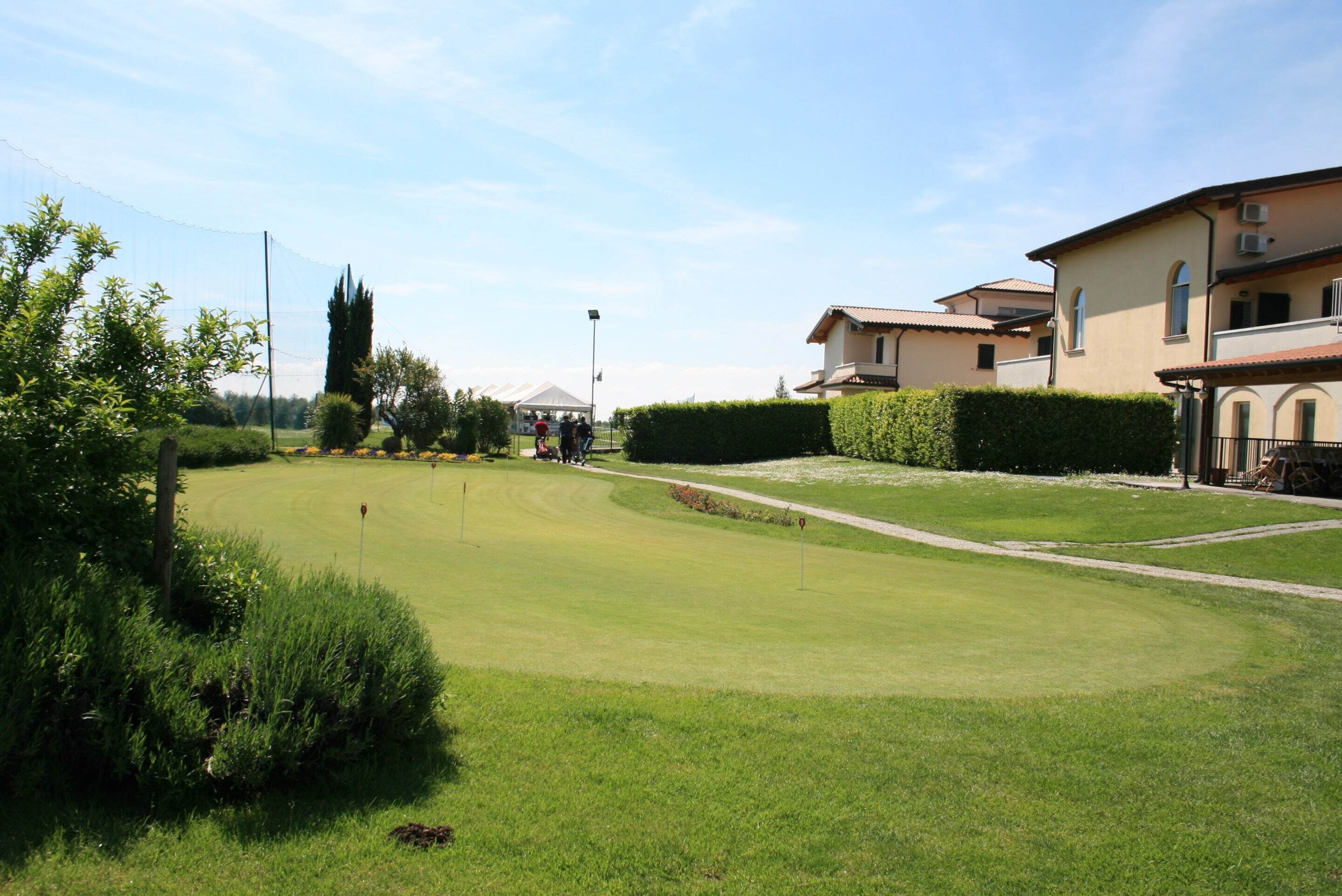 Een golfbaan met een duidelijke route, omringd door goed onderhouden hagen en bomen.