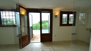 A room with a tiled floor, a door leading to a balcony, and a window with a view of greenery. - Farmhouse in Montecatini With Sauna & Pool (Pieve a Nievole)