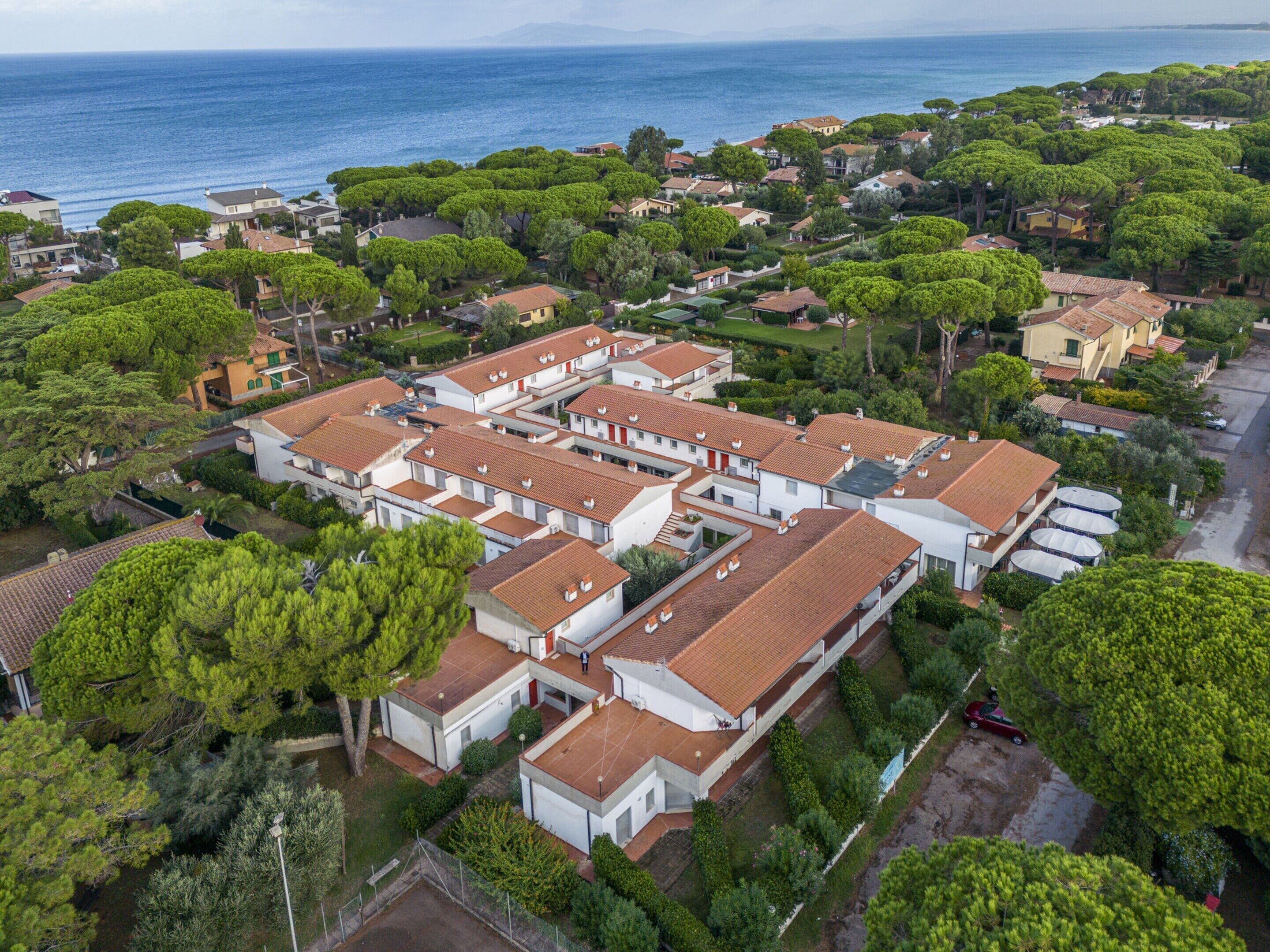 A coastal residential area with modern houses, a marina, and a view of the sea.