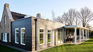 A modern house with a covered patio area. - Group Villa in Netherlands With Privacy (Voorthuizen)