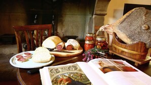 Une table avec du pain, des tranches de viande, des bocaux et un livre.