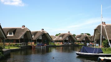 Un canal con casas a un lado y un bote amarrado al otro.